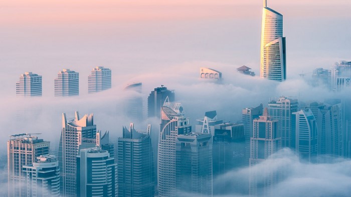 Cityscape shrouded in fog at sunrise