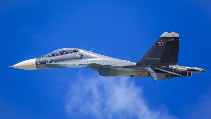 Su-30CM fighter jet flying in blue sky