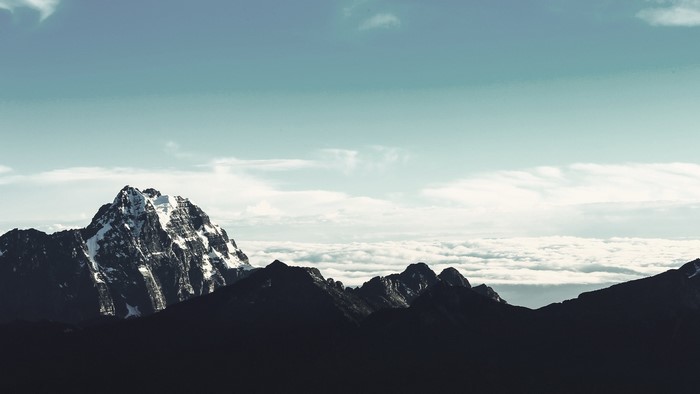Snow-capped mountain peak above clouds