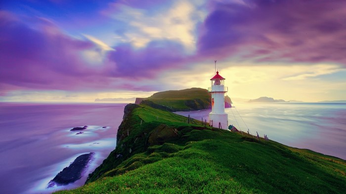 Lighthouse on a cliff in the Faroe Islands at sunset