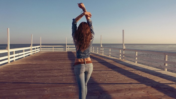 Woman on a pier stretching arms