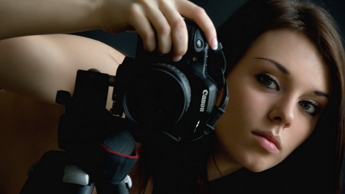 Woman holding a Canon camera on a tripod