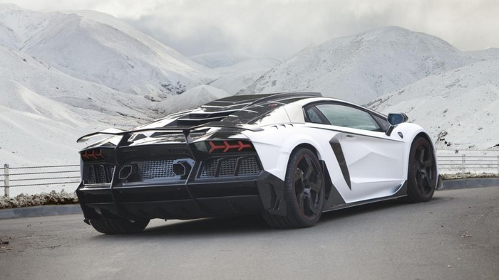 White and black Lamborghini Aventador in snowy mountains