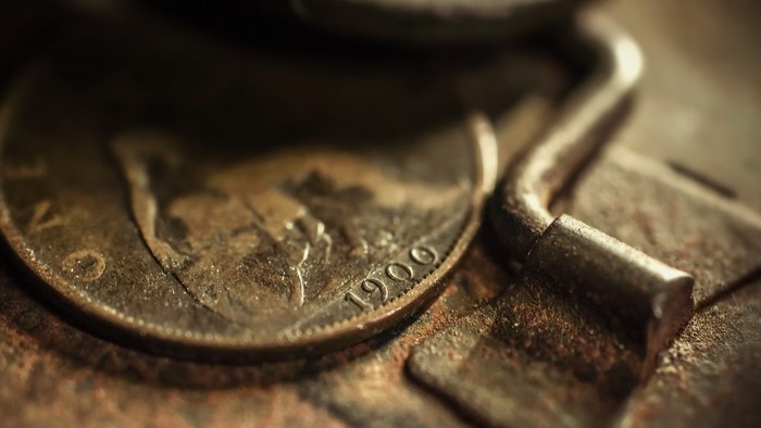 Close-up of a 1909 coin and a rusty lock