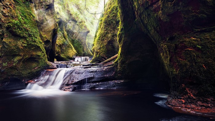 Mossy gorge with a waterfall and river