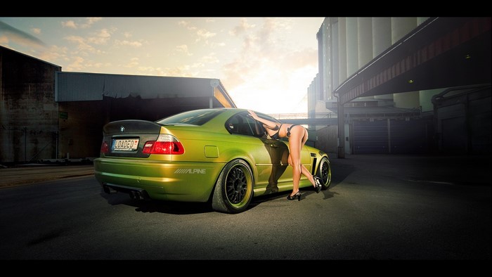 Woman leaning on a green BMW M3