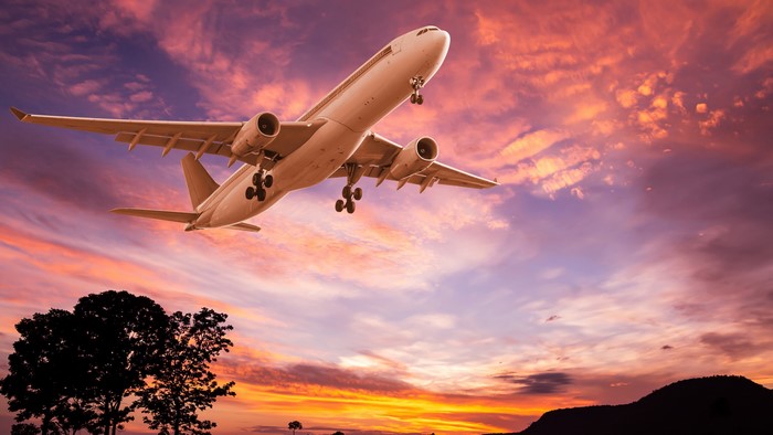 Airplane taking off at sunset