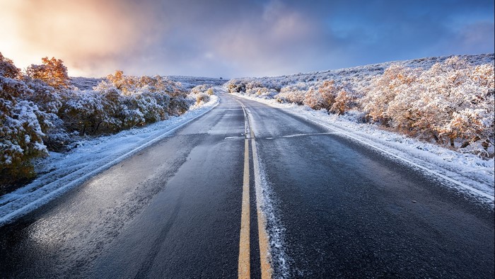 Wet road with snow on the sides