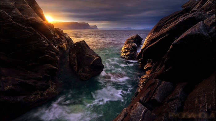 Sunrise over rocky coastline with ocean waves