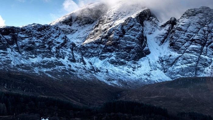 Snow-covered mountains with a small white house