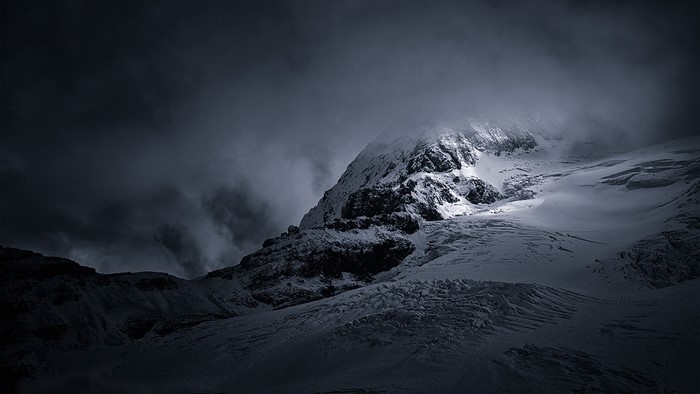Snowy mountains under dark clouds