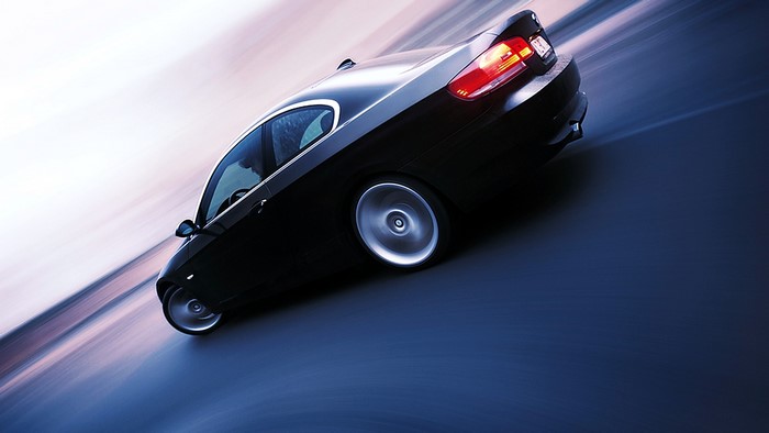 Black BMW coupe driving on a blurred road