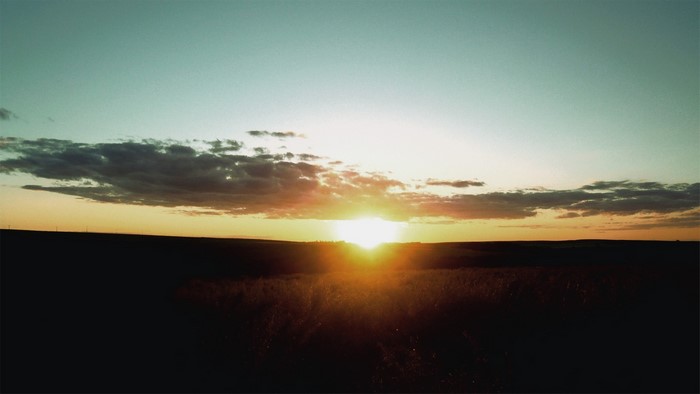Sunset over a field with clouds