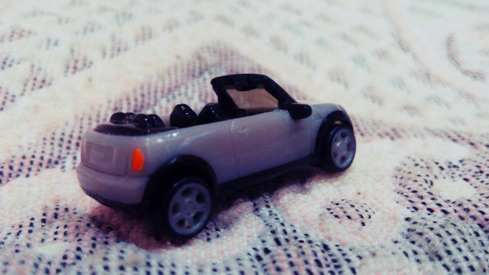 Gray convertible toy car on a patterned surface