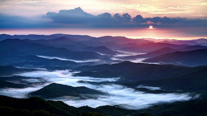 Mountain range at sunrise with fog