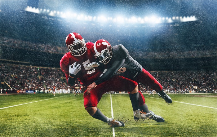 American football players in rain at stadium