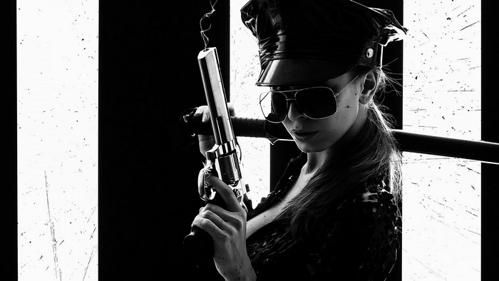 Woman in police hat holding a gun