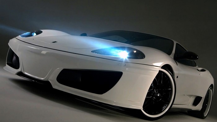 White Ferrari sports car with headlights on