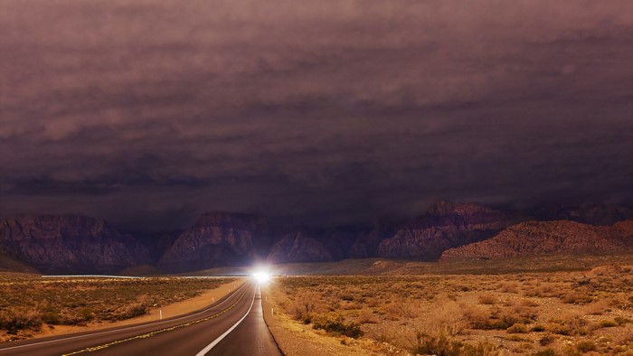 Road through desert landscape at dusk