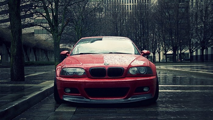 Red BMW E46 M3 parked on a wet street