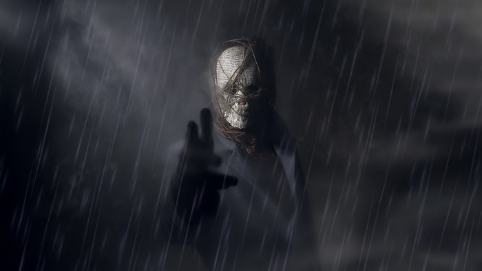 A figure with a book-covered face in the rain