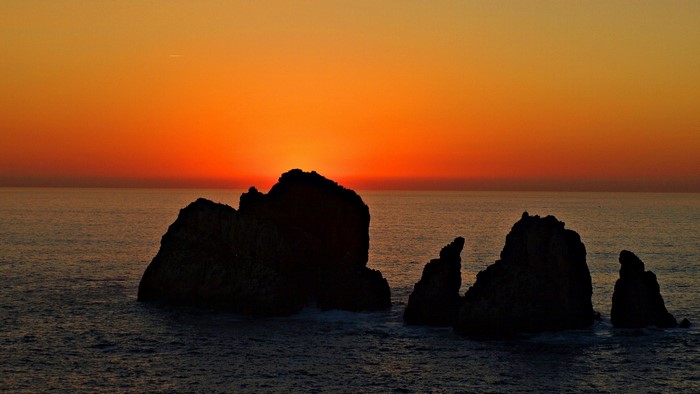 Sunset over the ocean with rock formations