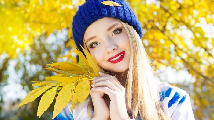 Girl in blue beanie with yellow leaves