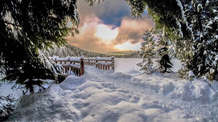 Winter scene with snow-covered wooden pier and frozen lake