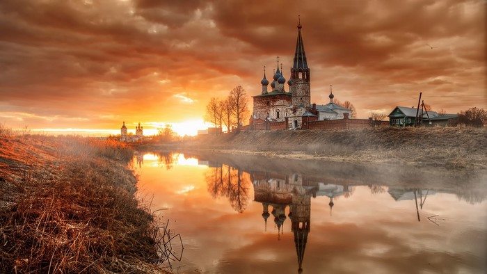 Church reflected in river at sunset, Dunilovo village