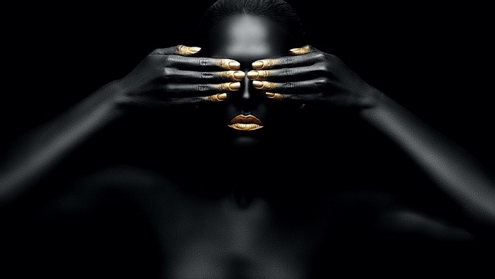 Woman with black skin and gold accents covering eyes