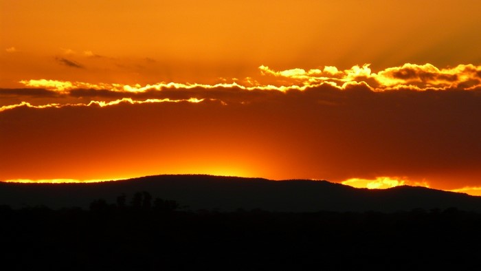 Sunset over silhouetted hills