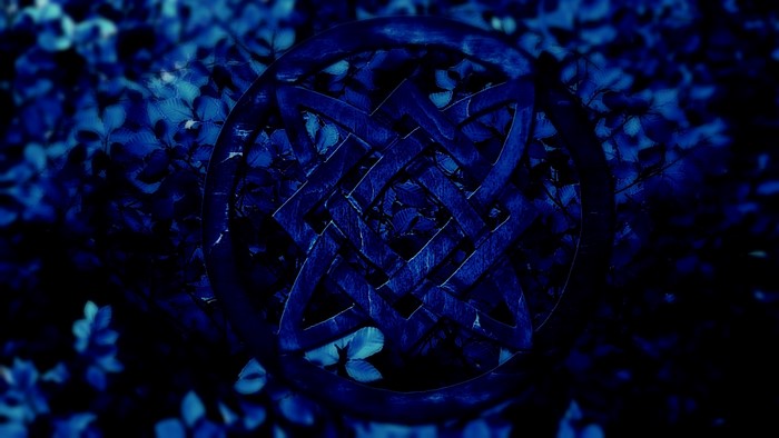 Blue Celtic Knot Symbol on Dark Foliage