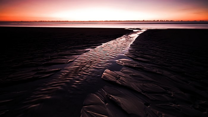 Sunset over a stream on a beach