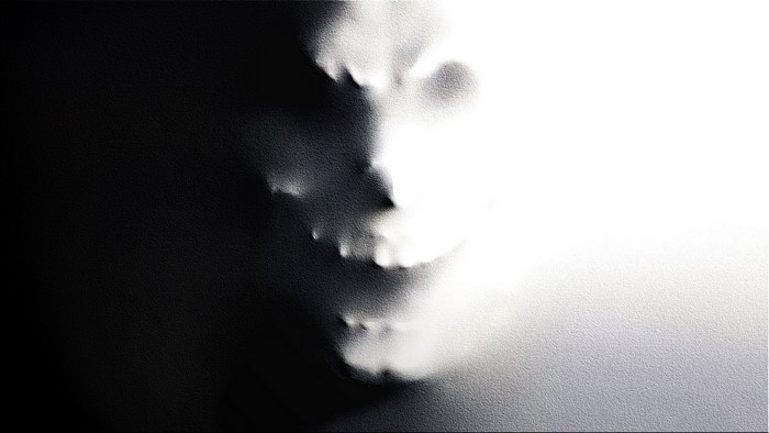 Face emerging from darkness and light