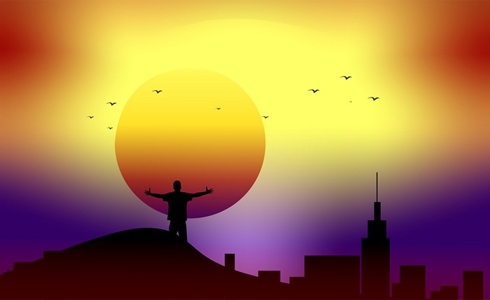 Silhouette of a man with arms outstretched at sunset