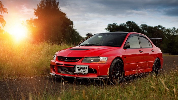 Red Mitsubishi Lancer Evolution on a dirt road