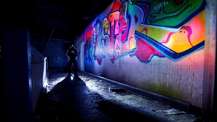 Person standing in front of graffiti wall