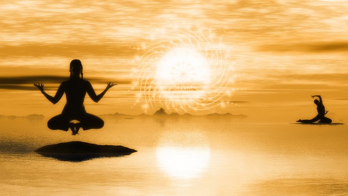 Two people meditating in a surreal landscape at sunset