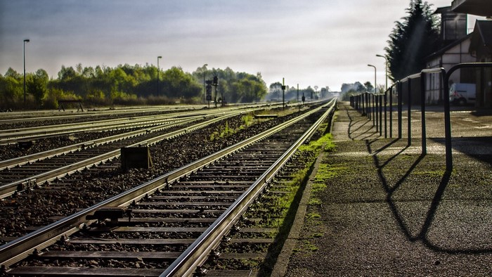 Train tracks at a station with trees and buildings