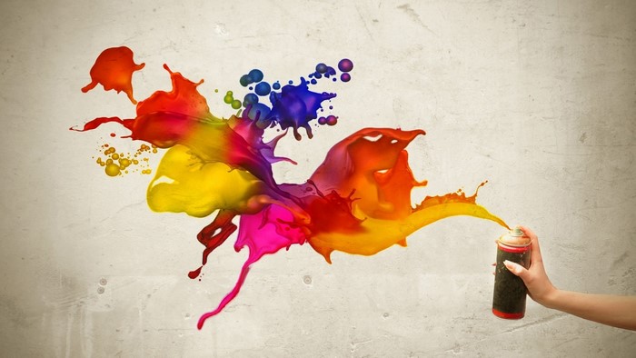 Spray paint can creating colorful splashes on a wall