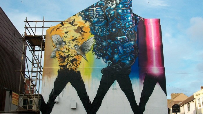 Street art mural of a skeleton and birds in North Laine, Brighton