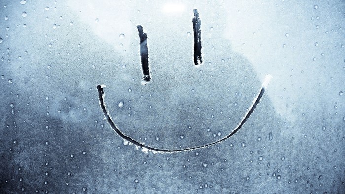 Smiley face drawn on a wet window