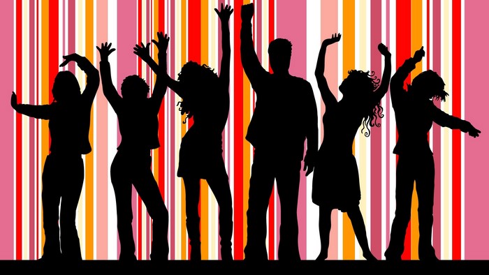 Silhouettes of people dancing against a colorful striped background