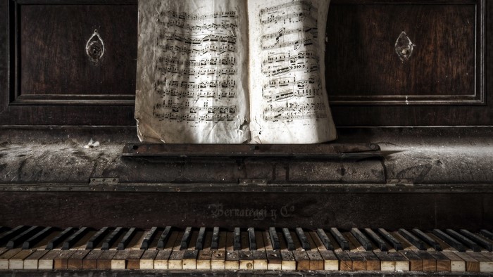 Old broken piano with sheet music