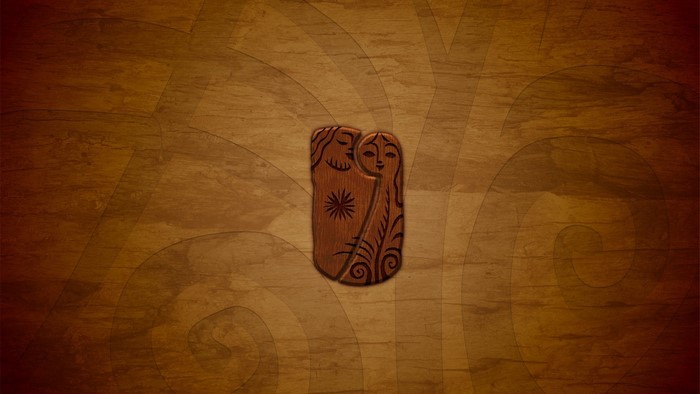 Wooden carving of two figures on a textured background