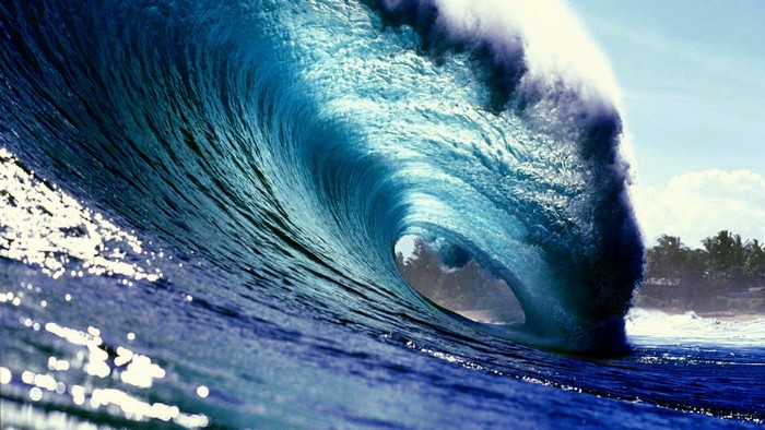 Ocean wave crashing with sunlight