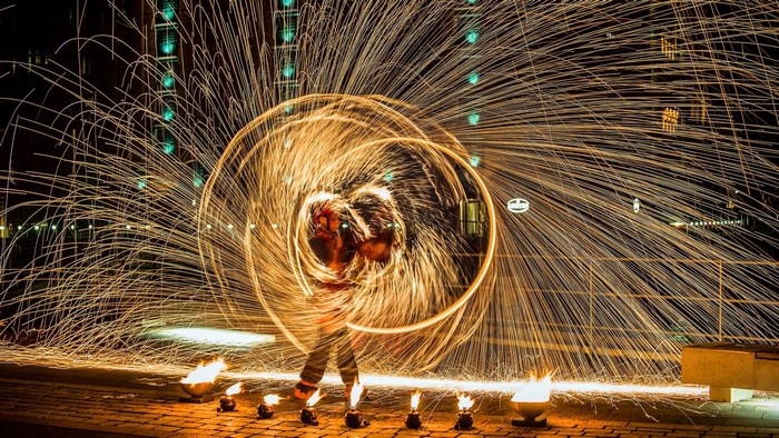 Man performing fire spinning with sparks