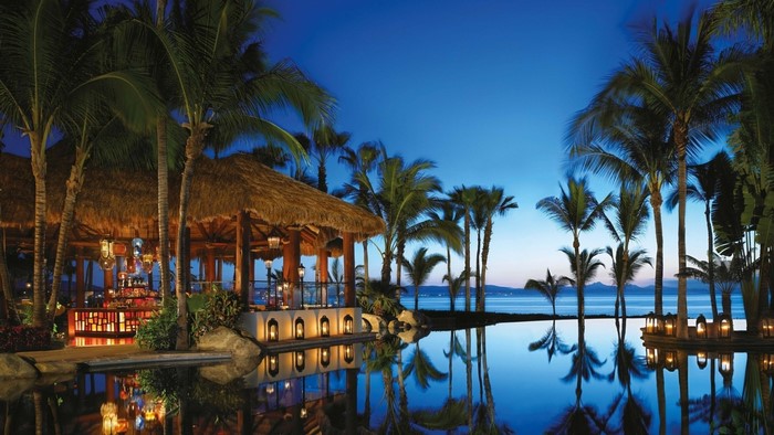 Tropical resort bar with infinity pool at dusk