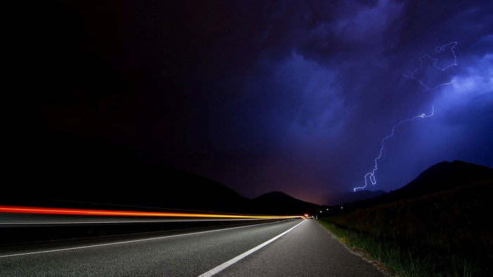 Time lapse of lightning over a road at night