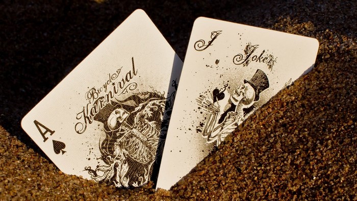 Ace of Spades and Joker cards on sand